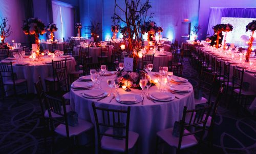 Decorated wedding hall with candles, round tables and centerpieces